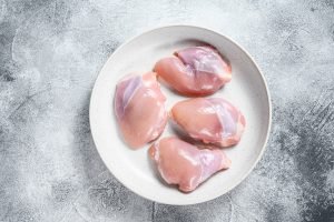 Raw chicken drumstick fillet. Gray background. 